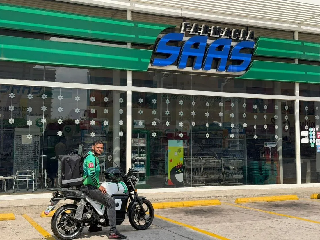 Conductor de Logixtogo frente a una sucursal de Farmacia SAAS